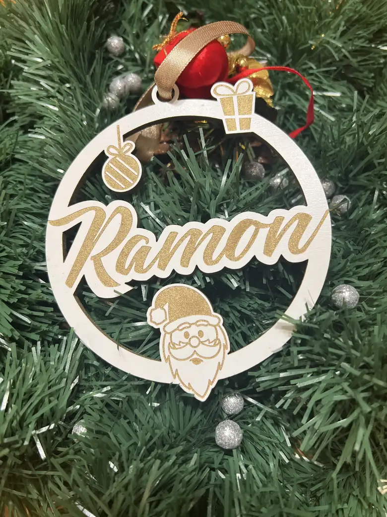 Bola de Navidad de madera blanca con el nombre Ramon, colgada en el árbol